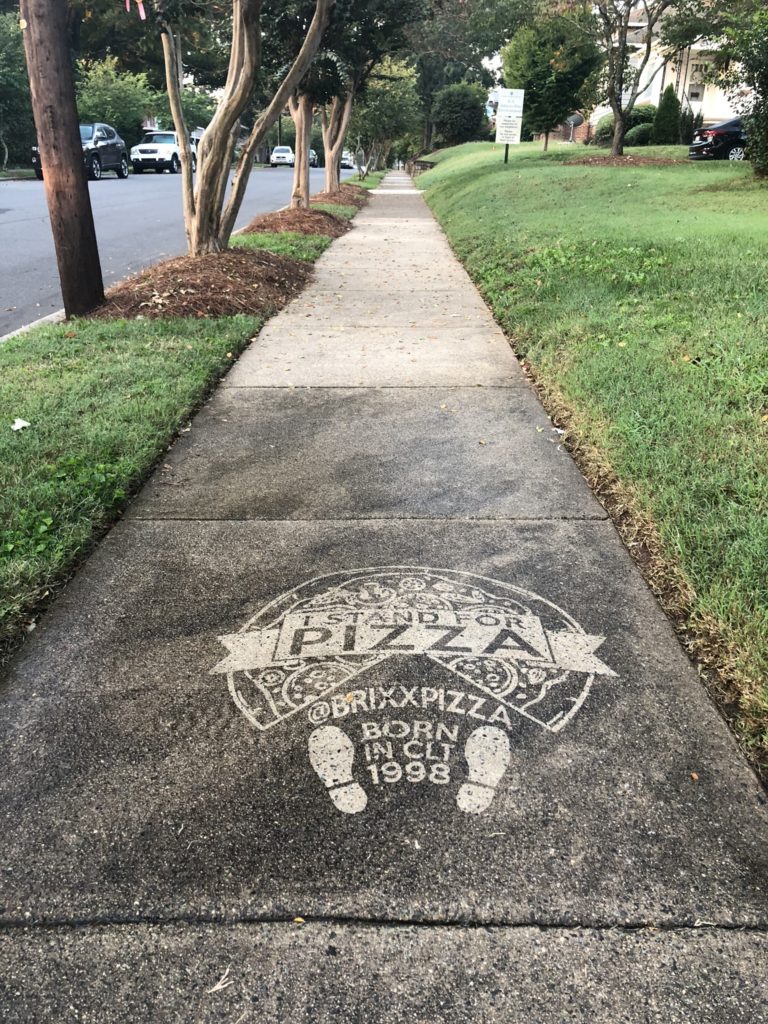 pressure washed pizza celebrating Brixx Pizza on the sidewalk.