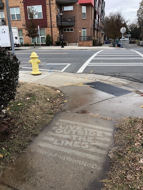 Clean Graffiti for Warp + Weft on the corner of a busy Charlotte, NC intersection