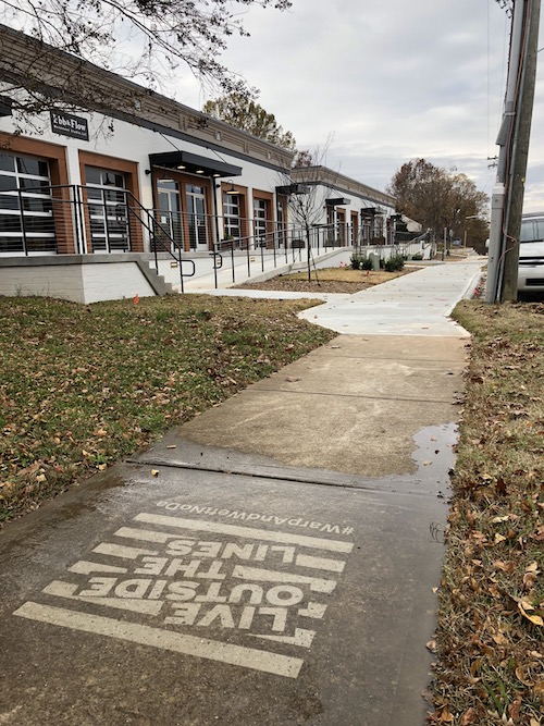 Pressure washed art on a dirty piece of sidewalk.