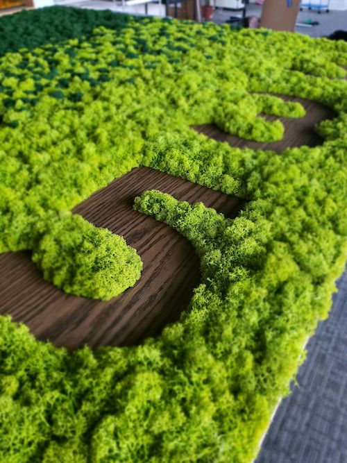 close up of wooden number "5" inset into a moss art wall