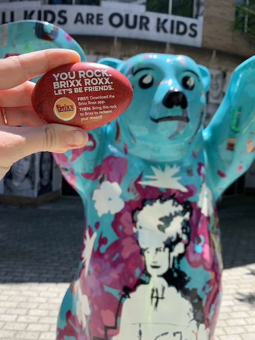 Branded red Brixx rock in front of a cool, colorful art-covered bear in Charlotte, NC.