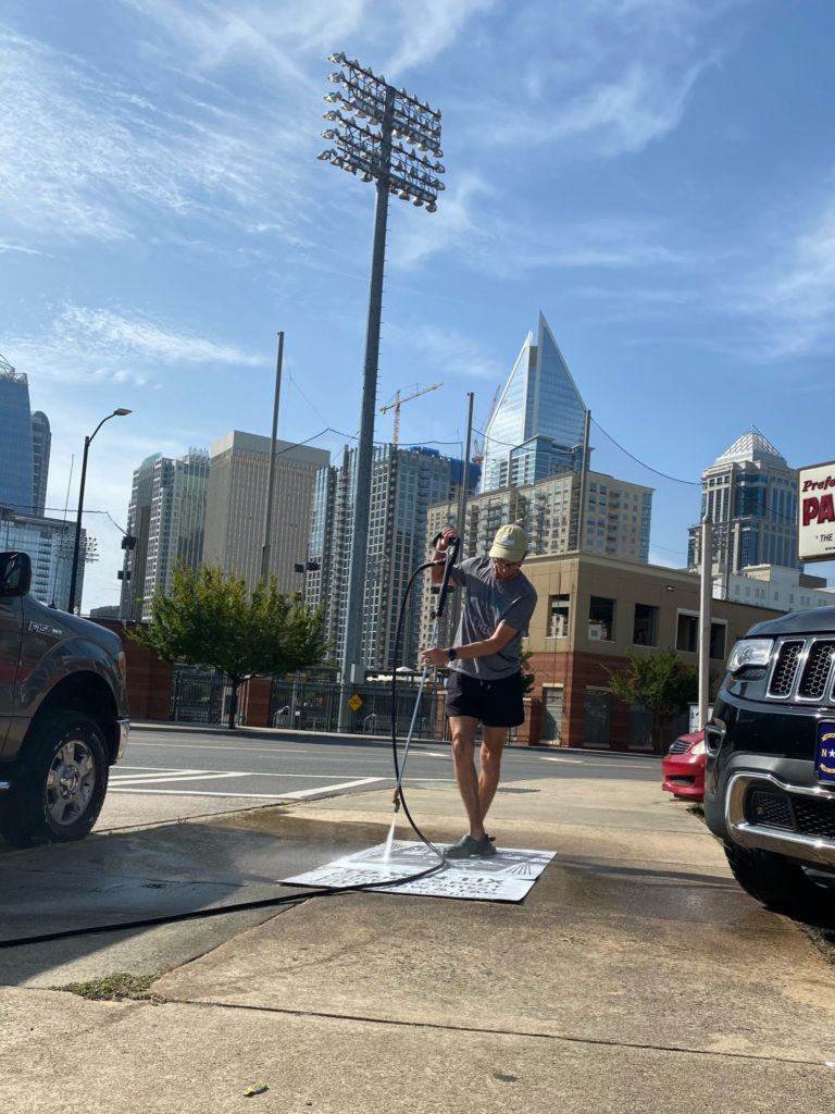 The Savage Way pressure washes an advertisement onto the sidewalk for the Carolina Panthers